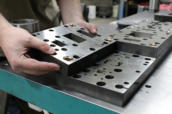 Custom progressive in-die tapping being assembled